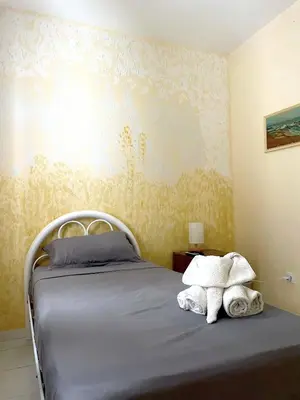 a bedroom with a bed with towels on it at Cantinho C - Alojamento Complementar in Praia