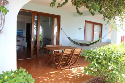 a hammock on the back porch of a house at Oceanfront Apt 4 Porto Antigo II in Santa Maria