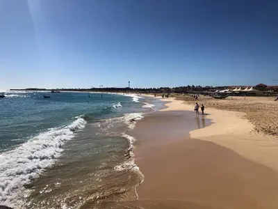 a group of people walking on the beach at Oceanfront Apt 4 Porto Antigo II in Santa Maria