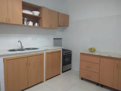 a kitchen with wooden cabinets and a sink and a stove at Casa Pé di Polon holiday home in Picos