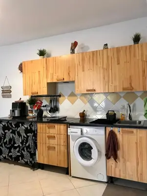 a kitchen with a washing machine and wooden cabinets at Blue Ocean in Santa Maria