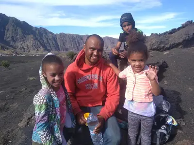 a man and two children posing for a picture in the mountains at Ciza e Rose in Portela