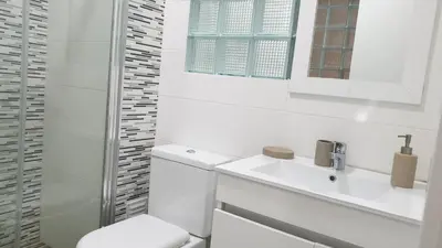 a white bathroom with a toilet and a sink at Sonho Appartement in Praia