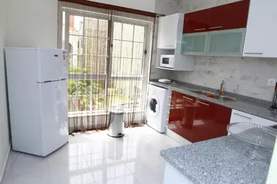 a kitchen with a white refrigerator and a washing machine at Sonho Appartement in Praia