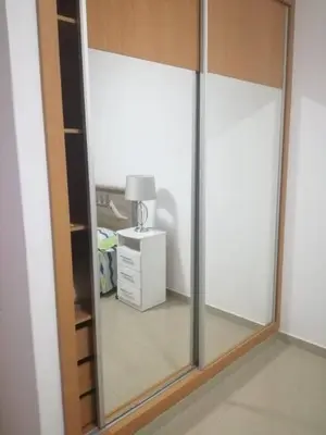 a mirror in a room with a lamp and a dresser at Appartement de Revé in Praia