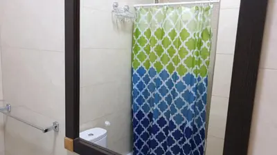 a bathroom with a shower with a blue and green shower curtain at Appartement de Revé in Praia