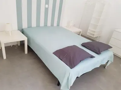 a white bed with two tables and two pillows on it at Casa Io - Goraz in Mindelo