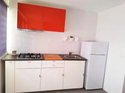 a kitchen with white cabinets and a white refrigerator at Casa Io - Goraz in Mindelo