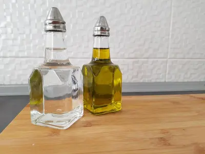 two bottles of oil sitting on a wooden table at Casa Io - Goraz in Mindelo