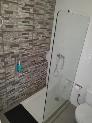 a bathroom with a glass shower and a toilet at Casa Io - Goraz in Mindelo