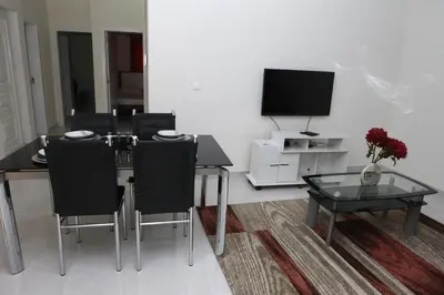 a dining room with a table and chairs and a television at Apartamento Micael in Praia