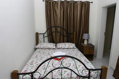 a bedroom with a bed with a flowered bedspread at Apartamento Micael in Praia