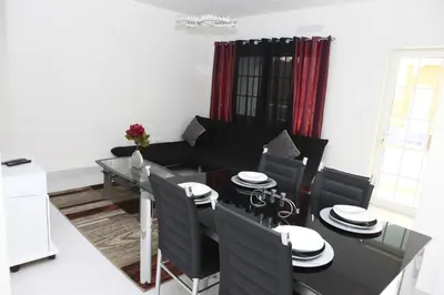 a living room with a black couch and a table at Apartamento Micael in Praia