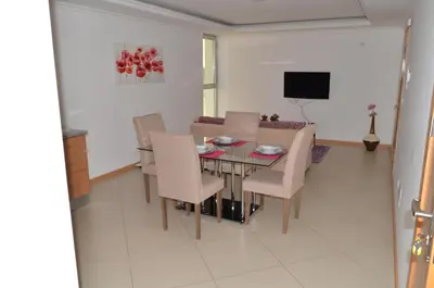 a dining room with a table and chairs and a television at Apartamento Ireny in Praia