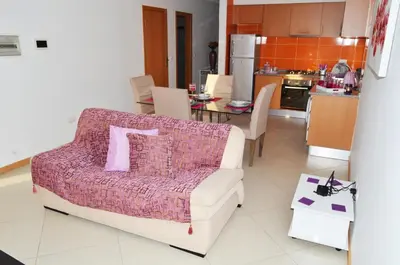 a living room with a couch and a kitchen at Apartamento Ireny in Praia