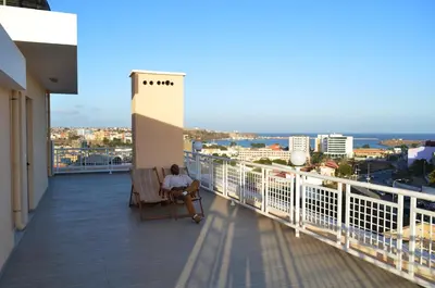 a person sitting in a chair on a balcony at Apartamento Ireny in Praia