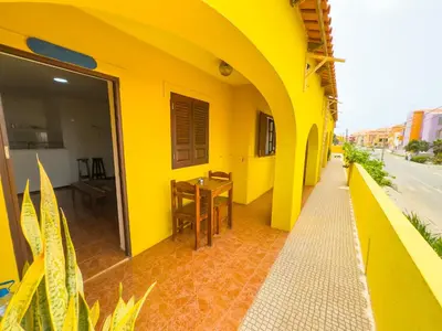 a yellow building with a table and a dining room at Misturod - Holiday Apartments in Santa Maria