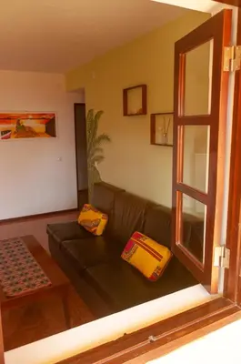 a living room with a green couch with two yellow pillows at Misturod - Holiday Apartments in Santa Maria