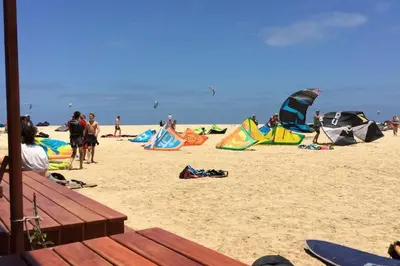 a group of people on a beach with kites at Good value low cost apartment second beach line in Santa Maria