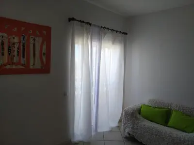 a living room with a chair and a window at Good value low cost apartment second beach line in Santa Maria
