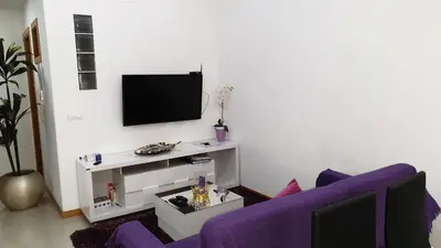 a living room with a purple couch and a tv at Jessica Appartment in Praia