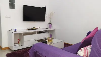 a living room with a purple couch and a tv at Jessica Appartment in Praia