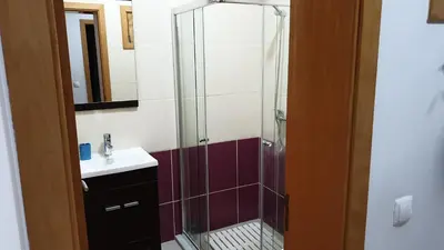 a bathroom with a glass shower and a sink at Jessica Appartment in Praia