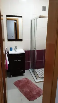 a bathroom with a sink and a shower with a mirror at Jessica Appartment in Praia