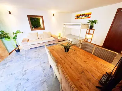 a living room with a wooden table and a couch at Penthouse with rooftopbar, Fiber WiFi, next to the beach! in Santa Maria