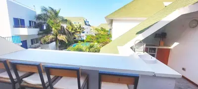 a balcony with chairs and a sink on a building at Penthouse with rooftopbar, Fiber WiFi, next to the beach! in Santa Maria