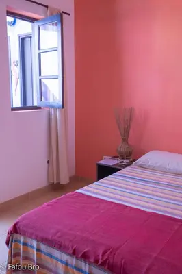 a bedroom with red walls and a bed with a window at Sakaroule B&B in Santa Maria