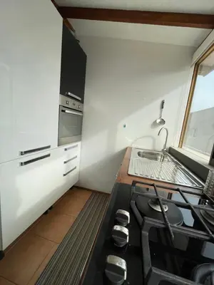 a small kitchen with a stove and a sink at Blue Eagle Guesthouse - Casa de hospedes in Santa Maria
