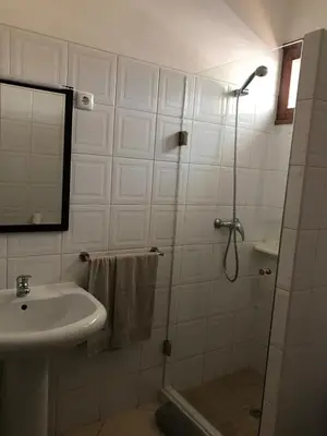 a bathroom with a sink and a shower with a mirror at Blue Eagle Guesthouse - Casa de hospedes in Santa Maria
