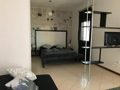 a living room with a bed and a television at Blue Eagle Guesthouse - Casa de hospedes in Santa Maria