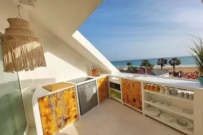 a kitchen with a view of the beach at Beach penthouse with rooftopbar and Fiber WiFi, spectacular 180 degrees ocean view in Santa Maria