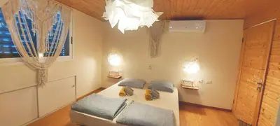 a bedroom with a bed and a chandelier at Beach penthouse with rooftopbar and Fiber WiFi, spectacular 180 degrees ocean view in Santa Maria