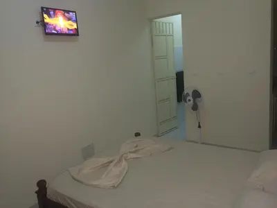 a bedroom with a bed and a tv on the wall at Pensao Motel Sodade in São Filipe