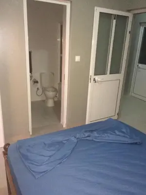 a bedroom with a bed and a bathroom with a toilet at Pensao Motel Sodade in São Filipe