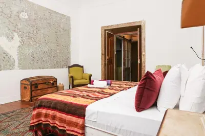a bedroom with a bed and a chair at Casa Colonial Koenig in São Filipe