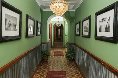a hallway with green walls and a chandelier at Casa Colonial Koenig in São Filipe