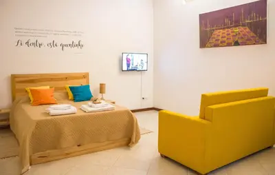 a bedroom with a bed and a yellow chair at Apartamento Xandinha Amwilla Guesthouse in Mindelo