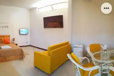 a living room with a yellow couch and a table at Apartamento Xandinha Amwilla Guesthouse in Mindelo