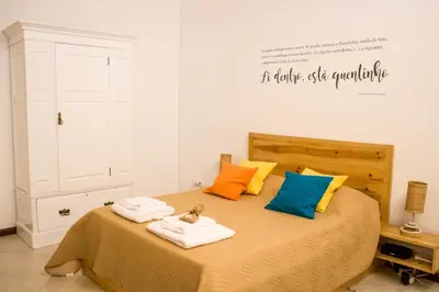 a bedroom with a bed with towels on it at Apartamento Xandinha Amwilla Guesthouse in Mindelo