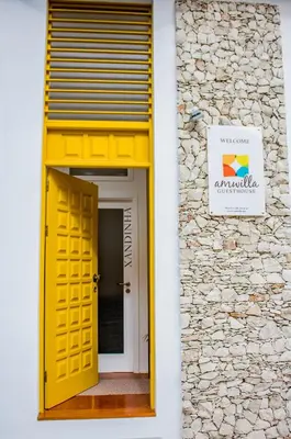 a yellow door on the side of a building at Apartamento Xandinha Amwilla Guesthouse in Mindelo