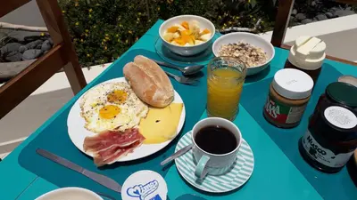 a blue table with a plate of breakfast food and coffee at B&B Sereia Azul Boa Vista in Sal Rei