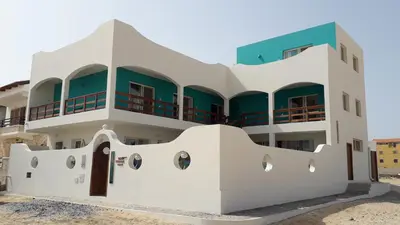 a white building with a green roof at B&B Sereia Azul Boa Vista in Sal Rei
