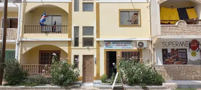 a yellow building with an american flag on a balcony at ka-Bela in Sal Rei