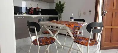 a kitchen with a white table with chairs with orange andchromeussion at ka-Bela in Sal Rei