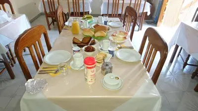 a table with a white table cloth with food on it at Residencial Vitoria in Ponta do Sol