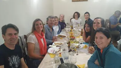 a group of people sitting at a dinner table at Residencial Vitoria in Ponta do Sol